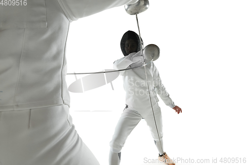 Image of Teen girls in fencing costumes with swords in hands isolated on white background