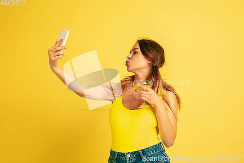 Image of Caucasian woman\'s portrait isolated on yellow studio background