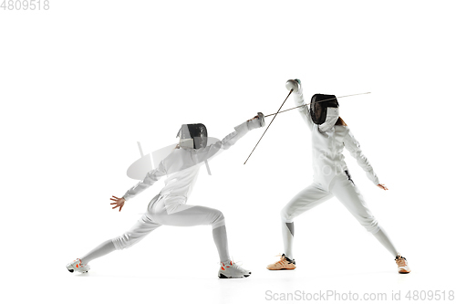 Image of Teen girls in fencing costumes with swords in hands isolated on white background