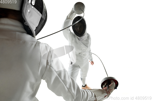 Image of Teen girls in fencing costumes with swords in hands isolated on white background