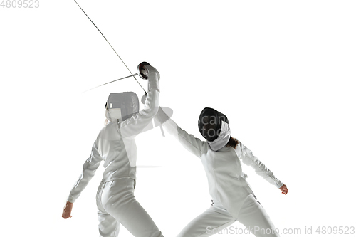 Image of Teen girls in fencing costumes with swords in hands isolated on white background