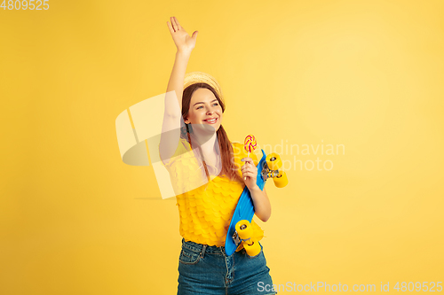 Image of Caucasian woman\'s portrait isolated on yellow studio background