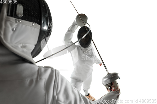 Image of Teen girls in fencing costumes with swords in hands isolated on white background