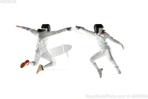 Image of Teen girls in fencing costumes with swords in hands isolated on white background