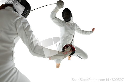 Image of Teen girls in fencing costumes with swords in hands isolated on white background