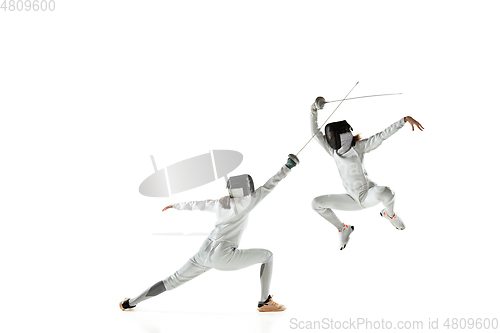 Image of Teen girls in fencing costumes with swords in hands isolated on white background