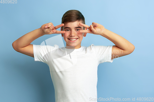 Image of Caucasian teen\'s portrait isolated on blue studio background