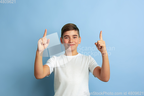 Image of Caucasian teen\'s portrait isolated on blue studio background