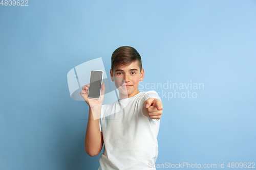 Image of Caucasian teen\'s portrait isolated on blue studio background