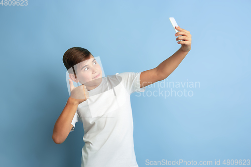 Image of Caucasian teen\'s portrait isolated on blue studio background