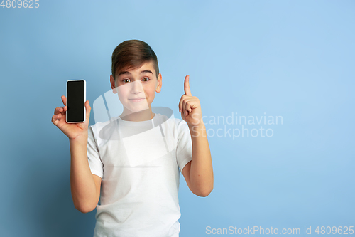 Image of Caucasian teen\'s portrait isolated on blue studio background