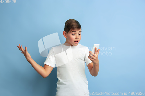Image of Caucasian teen\'s portrait isolated on blue studio background