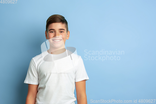Image of Caucasian teen\'s portrait isolated on blue studio background