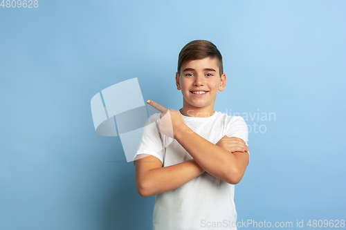 Image of Caucasian teen\'s portrait isolated on blue studio background