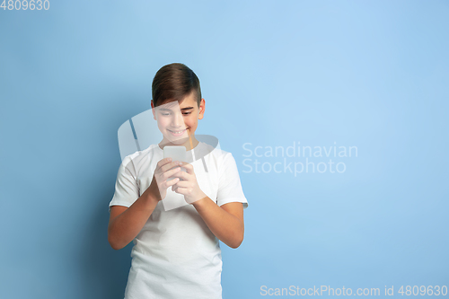Image of Caucasian teen\'s portrait isolated on blue studio background