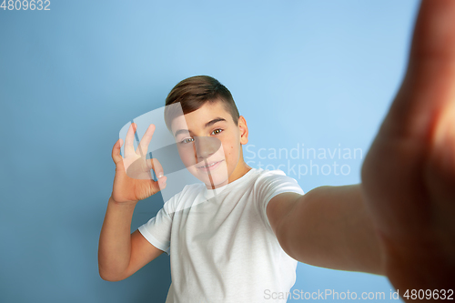 Image of Caucasian teen\'s portrait isolated on blue studio background