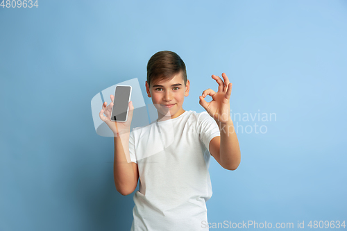 Image of Caucasian teen\'s portrait isolated on blue studio background