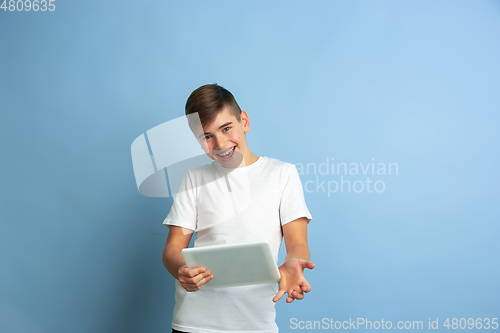 Image of Caucasian teen\'s portrait isolated on blue studio background