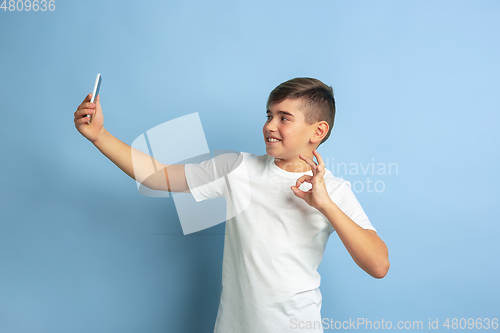 Image of Caucasian teen\'s portrait isolated on blue studio background