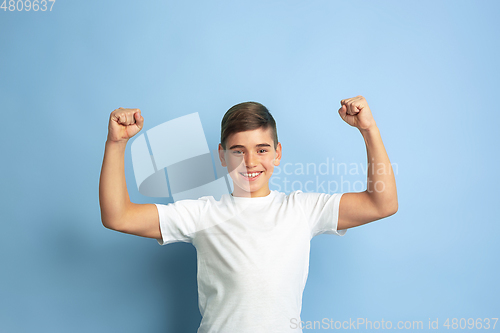 Image of Caucasian teen\'s portrait isolated on blue studio background