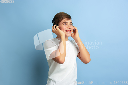 Image of Caucasian teen\'s portrait isolated on blue studio background