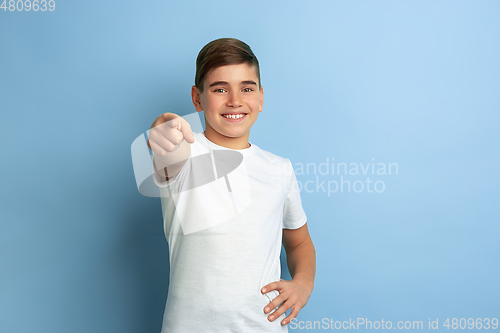 Image of Caucasian teen\'s portrait isolated on blue studio background