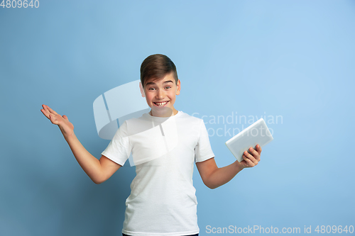 Image of Caucasian teen\'s portrait isolated on blue studio background