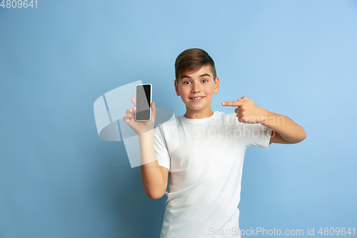 Image of Caucasian teen\'s portrait isolated on blue studio background
