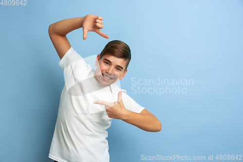 Image of Caucasian teen\'s portrait isolated on blue studio background