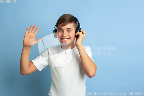 Image of Caucasian teen\'s portrait isolated on blue studio background