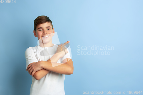 Image of Caucasian teen\'s portrait isolated on blue studio background