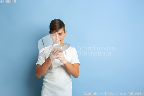 Image of Caucasian teen\'s portrait isolated on blue studio background