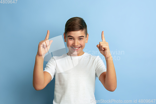 Image of Caucasian teen\'s portrait isolated on blue studio background