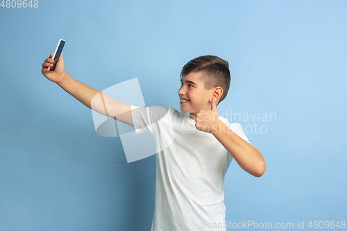 Image of Caucasian teen\'s portrait isolated on blue studio background