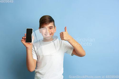 Image of Caucasian teen\'s portrait isolated on blue studio background