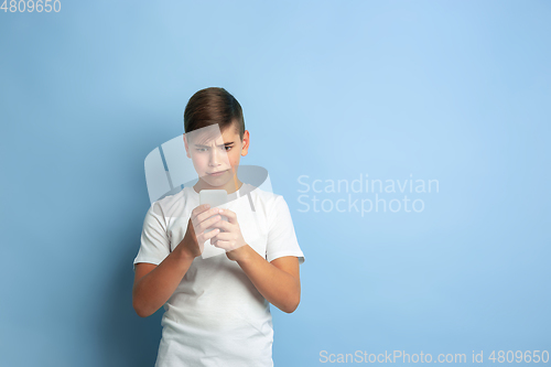 Image of Caucasian teen\'s portrait isolated on blue studio background