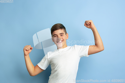 Image of Caucasian teen\'s portrait isolated on blue studio background