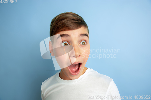 Image of Caucasian teen\'s portrait isolated on blue studio background