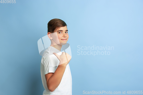 Image of Caucasian teen\'s portrait isolated on blue studio background