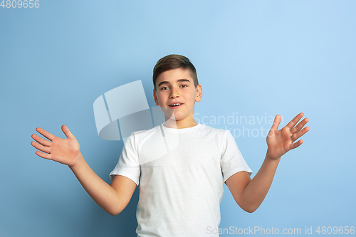 Image of Caucasian teen\'s portrait isolated on blue studio background