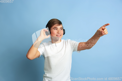 Image of Caucasian teen\'s portrait isolated on blue studio background