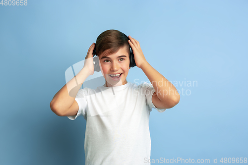 Image of Caucasian teen\'s portrait isolated on blue studio background