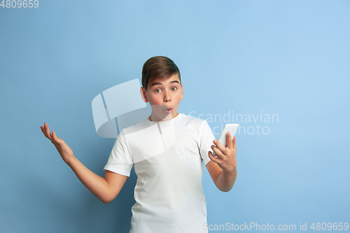 Image of Caucasian teen\'s portrait isolated on blue studio background