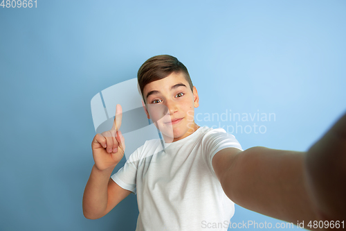 Image of Caucasian teen\'s portrait isolated on blue studio background