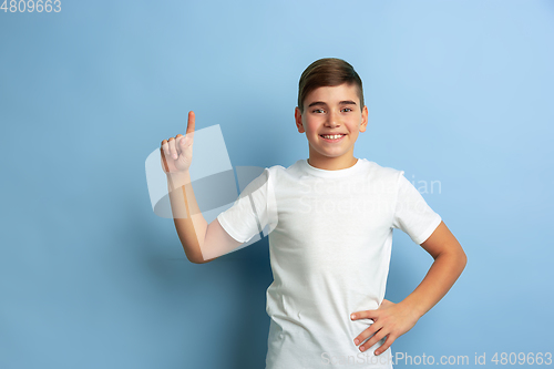 Image of Caucasian teen\'s portrait isolated on blue studio background