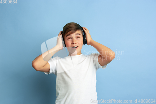 Image of Caucasian teen\'s portrait isolated on blue studio background