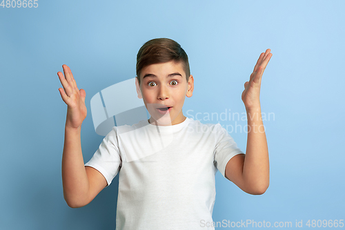 Image of Caucasian teen\'s portrait isolated on blue studio background