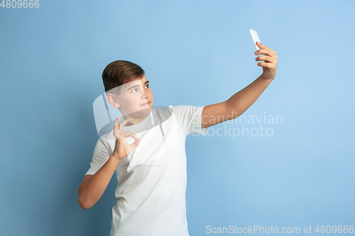 Image of Caucasian teen\'s portrait isolated on blue studio background
