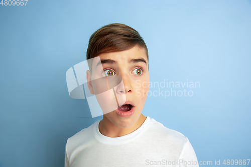 Image of Caucasian teen\'s portrait isolated on blue studio background