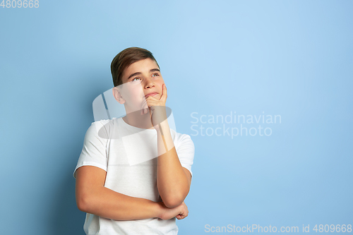 Image of Caucasian teen\'s portrait isolated on blue studio background
